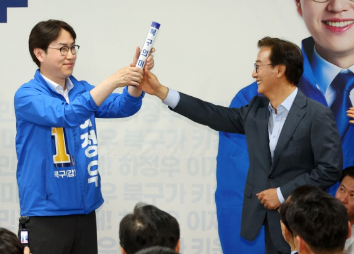 부산 북갑 국회의원 보궐선거에 출마하는 더불어민주당 하정우 후보가 10일 부산 북구에서 열린 선거사무소 개소식에서 전재수 부산시장 후보가 건넨 ‘북구의 미래’가 적힌 바톤을 넘겨 받고 있다. 연합뉴스