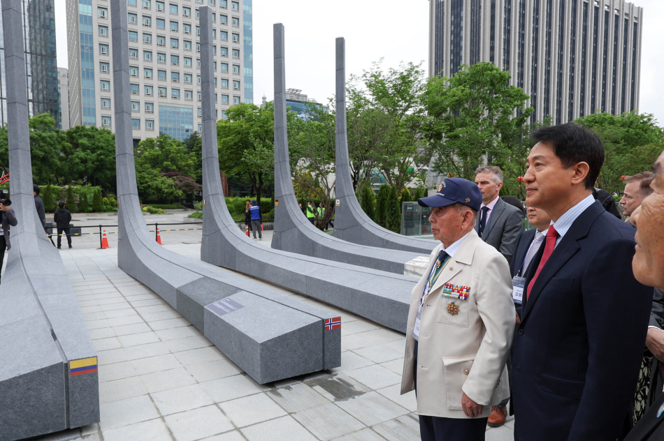 오세훈 국민의힘 서울시장 후보가 12일 서울 종로구 광화문광장에서 열린 ‘감사의 정원’ 준공식에 참석해 6·25 참전 유공자와 함께 석재 조형물을 보고 있다. 연합뉴스