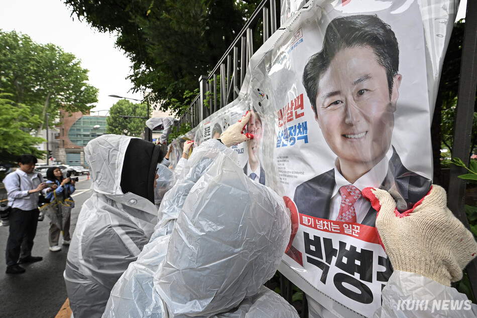 제9회 전국동시지방선거 공식 선거운동 첫날인 21일 서울 종로구 예술가의 집 담장에 서울시 선관위 관계자들이 선거벽보를 첩부하고 있다.