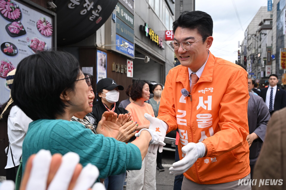 김정철 개혁신당 서울시장 후보가 21일 서울 사당역 인근에서 지지자들과 악수하고 있다.