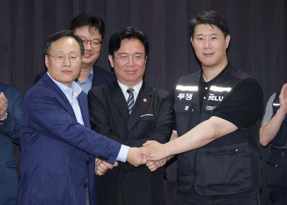 20일 경기도 수원시 장안구 경기고용노동청에서 열린 삼성전자 임금협상을 마친 후 여명구 삼성전자 DS(디바이스솔루션·반도체 사업 담당) 피플팀장과 최승호 삼성그룹 초기업노동조합 삼성전자지부 위원장이 잠정 합의안에 서명한 후 김영훈 고용노동부 장관과 손을 맞잡고 있다. 공동취재단