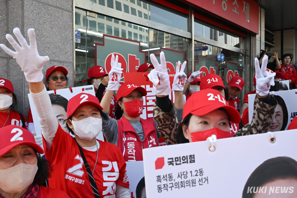 22일 서울 동작구 이수역 일대에서 국민의힘 선거운동원들이 오세훈 서울시장 후보의 발언에 환호하고 있다.