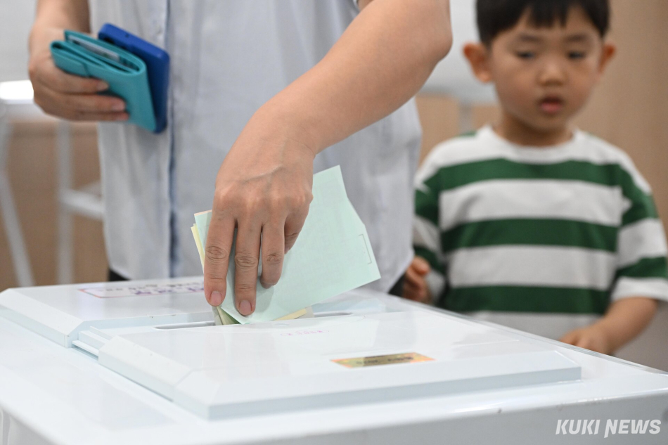 제9회 전국동시지방선거일인 3일 서울 동작구 상도4동주민센터에 마련된 투표소를 찾은 유권자가 투표함에 투표용지를 넣고 있다.