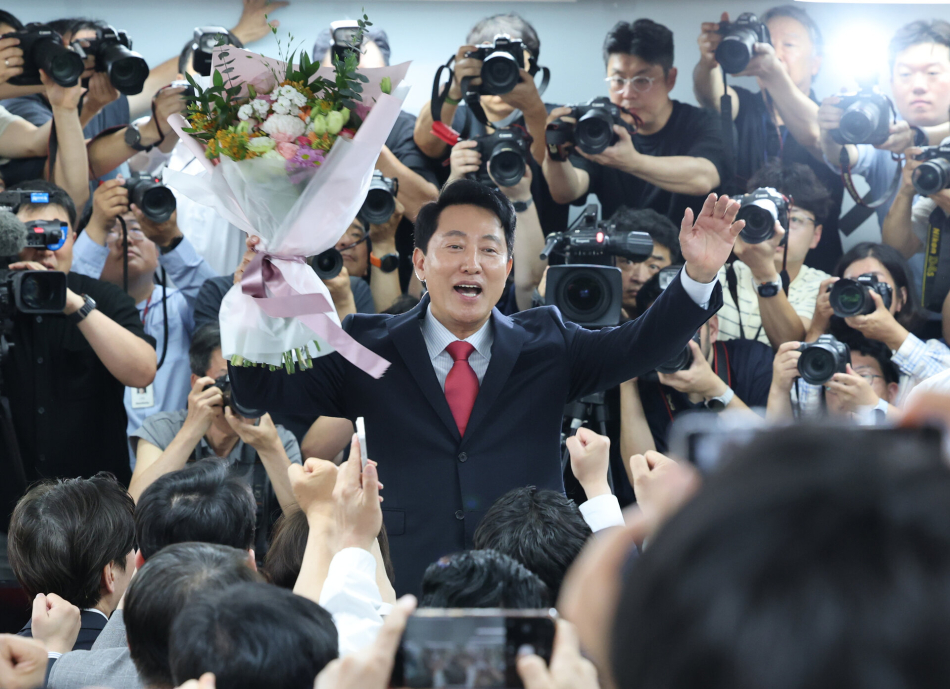 오세훈 국민의힘 서울시장 후보가 제9회 전국동시지방선거일 다음날인 4일 서울 종로구 대왕빌딩에 마련된 선거사무소에서 꽃다발을 들고 환호하고 있다.