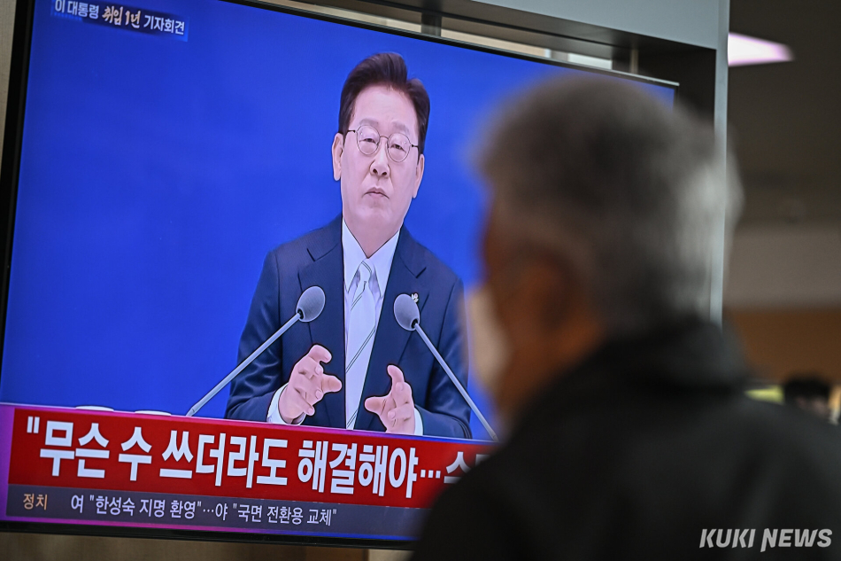 8일 서울역 대합실에서 한 시민이 이재명 대통령의 취임 1주년 기자회견을 시청하고 있다.
