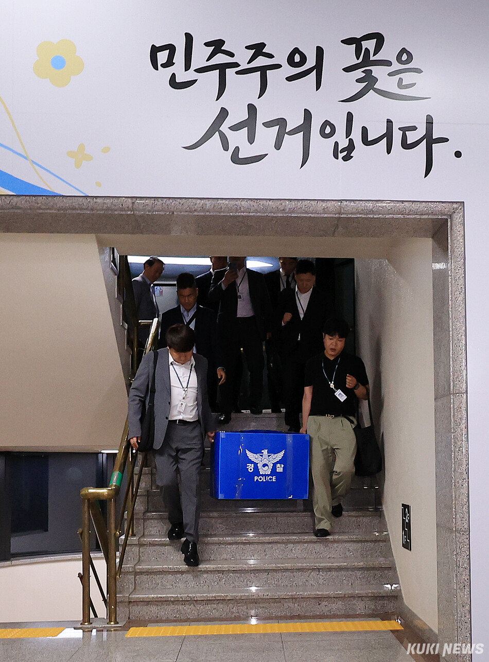 6·3 지방선거 투표용지 부족 사태를 수사하는 검경 합동수사본부 수사관들이 11일 경기 과천시 중앙선거관리위원회에 대한 압수수색을 마친 후 압수품 상자를 들고 이동하고 있다.